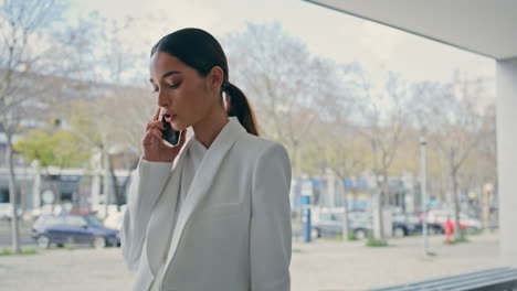 serious girl talking phone walking city building closeup. woman going to office