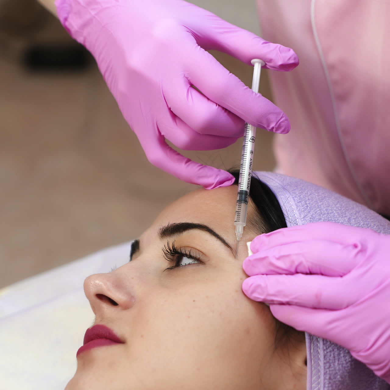 The doctor cosmetologist makes the Botulinum Toxin injection. Procedure for tightening and smoothing wrinkles. Rejuvenating facial injections.