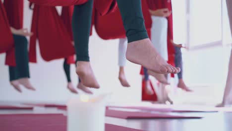 man bare feet hang down against women practicing meditation