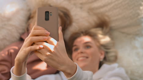 mother and little son lying and taking a selfie with a phone