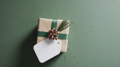 Video-of-christmas-presents-and-white-tag-with-copy-space-on-green-background