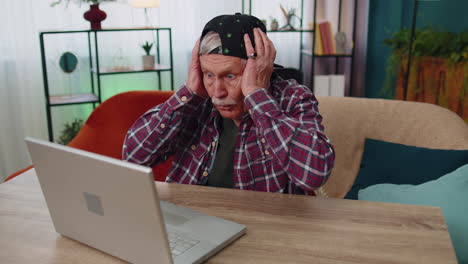 Amazed-senior-grandfather-use-laptop-computer,-receive-good-news-message,-shocked-by-sudden-win,-wow