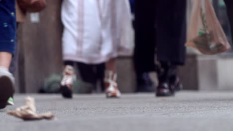 people walk on the street, close up to feet, shoes, boots, sneakers. day time, busy street. spring time.