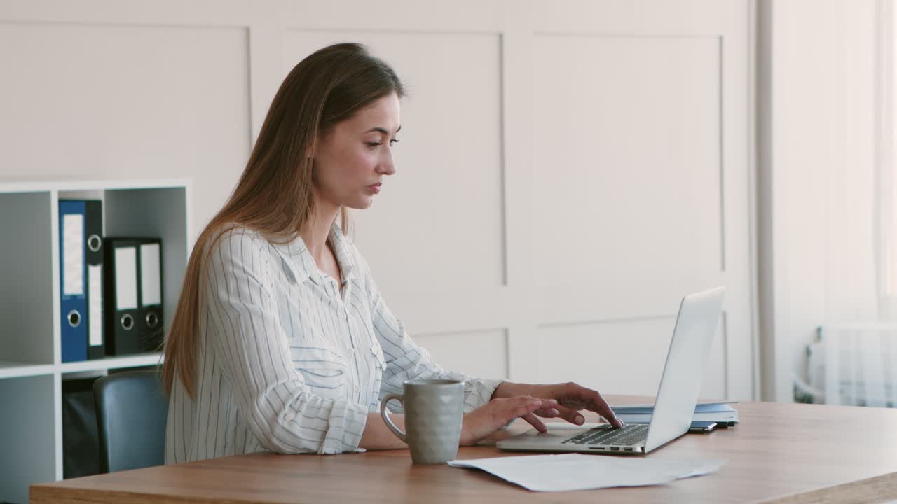 mujer bebiendo café y trabajando en un escritorio