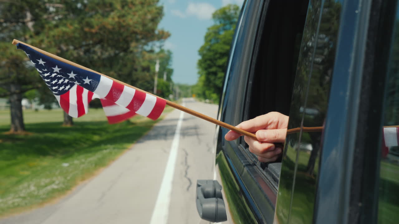 mano con la bandera de estados unidos en un concepto de escandinavia de viaje de ventana de coche