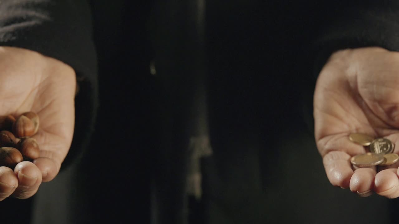 nueces en una mano y una moneda en la otra