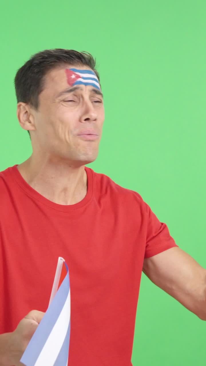 Nervous man cheering for Cuba during a match looking away