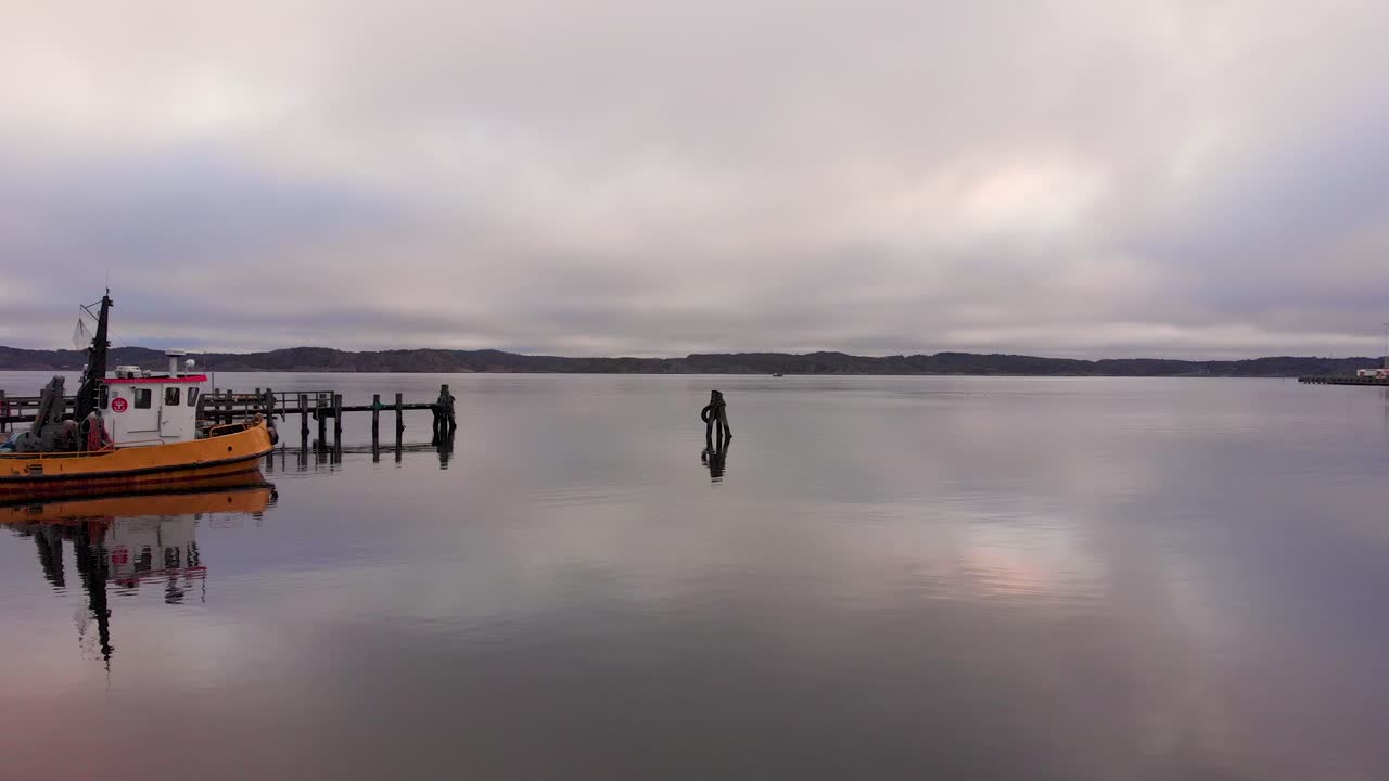 volando sobre las tranquilas aguas del antiguo puerto pesquero de lysekil en suecia - antena baja