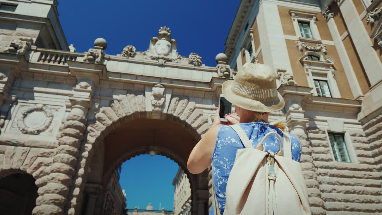 관광객은 스칸디나비아 개념의 스톡홀름 관광에서 의회 근처의 유명한 아치를 촬영합니다.