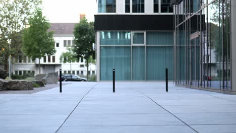 young businessman rides an e-scooter in front of modern buildings