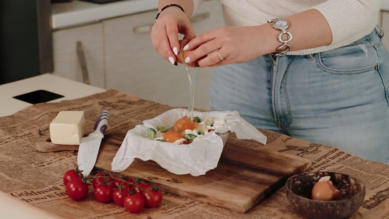 rompiendo un huevo cocinando una tortilla de verduras en una cocina moderna