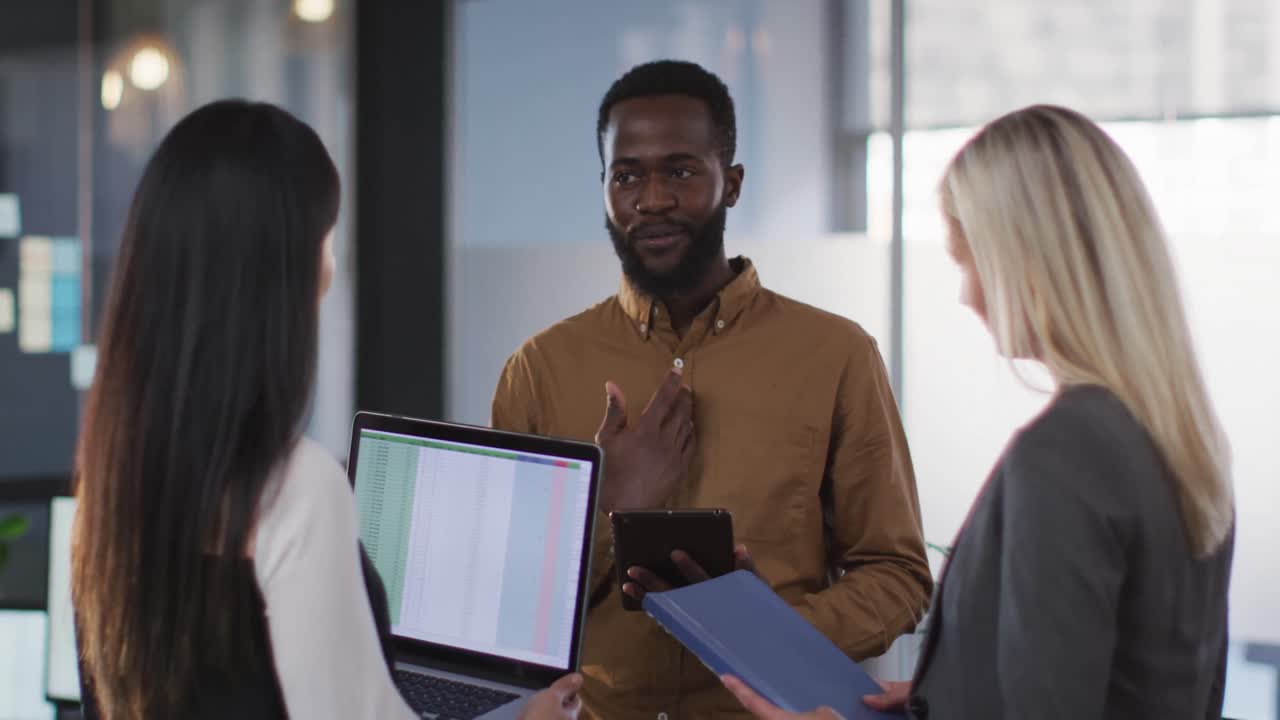 Group of diverse businesspeople discussing together and using laptop