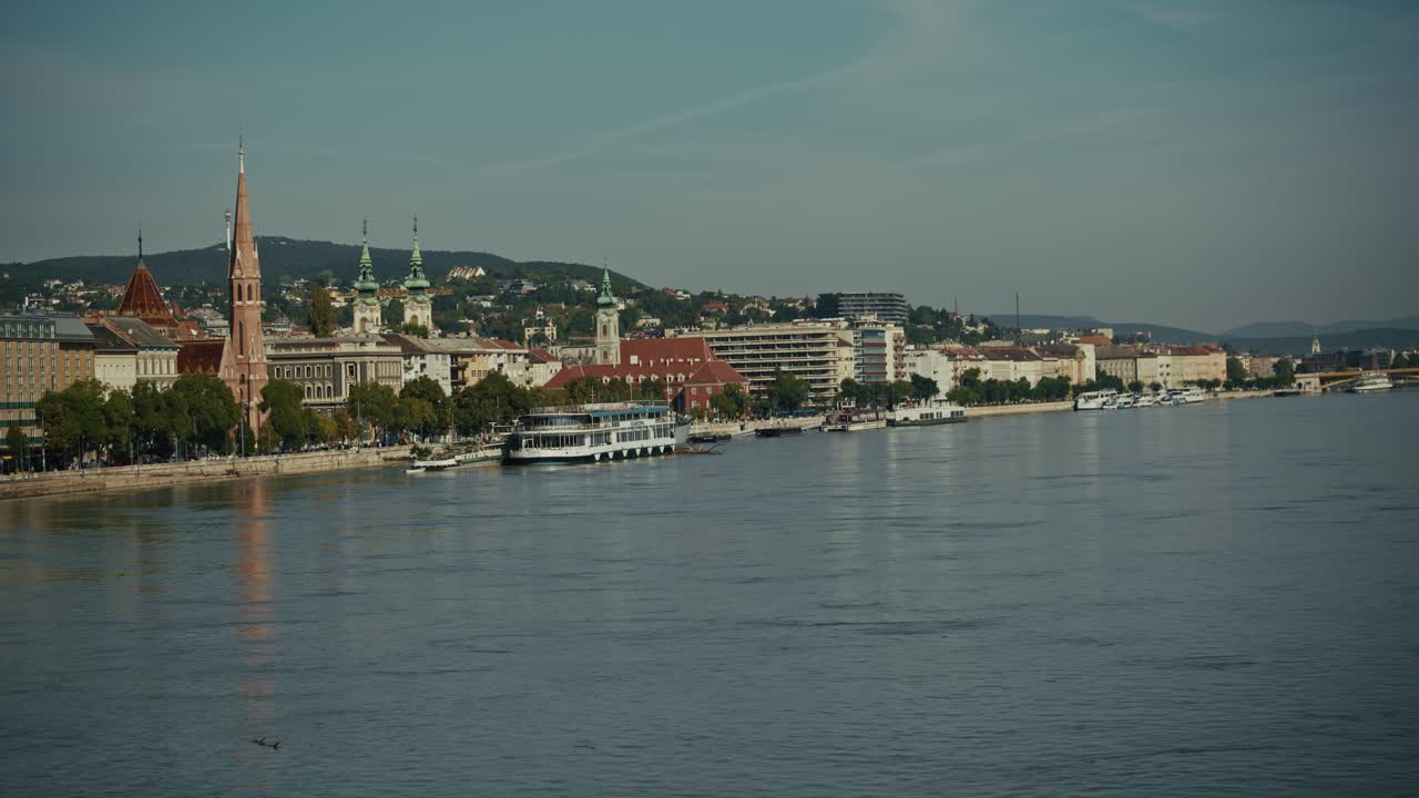 Vista panoramica di edifici e chiesa lungo il fiume Danubio durante l'alluvione di Budapest del 2024.