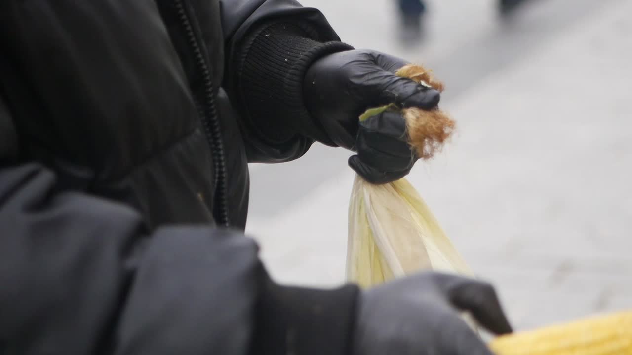 Person preparing corn on the cob