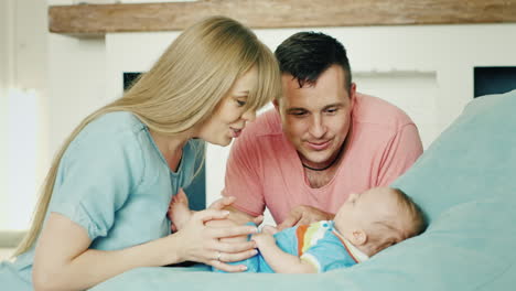 Young-Mom-And-Dad-Looking-At-Sveogo-Baby-The-Boy-Is-Two-Months-The-Parents-Smile-At-Him-A-Happy-Fami