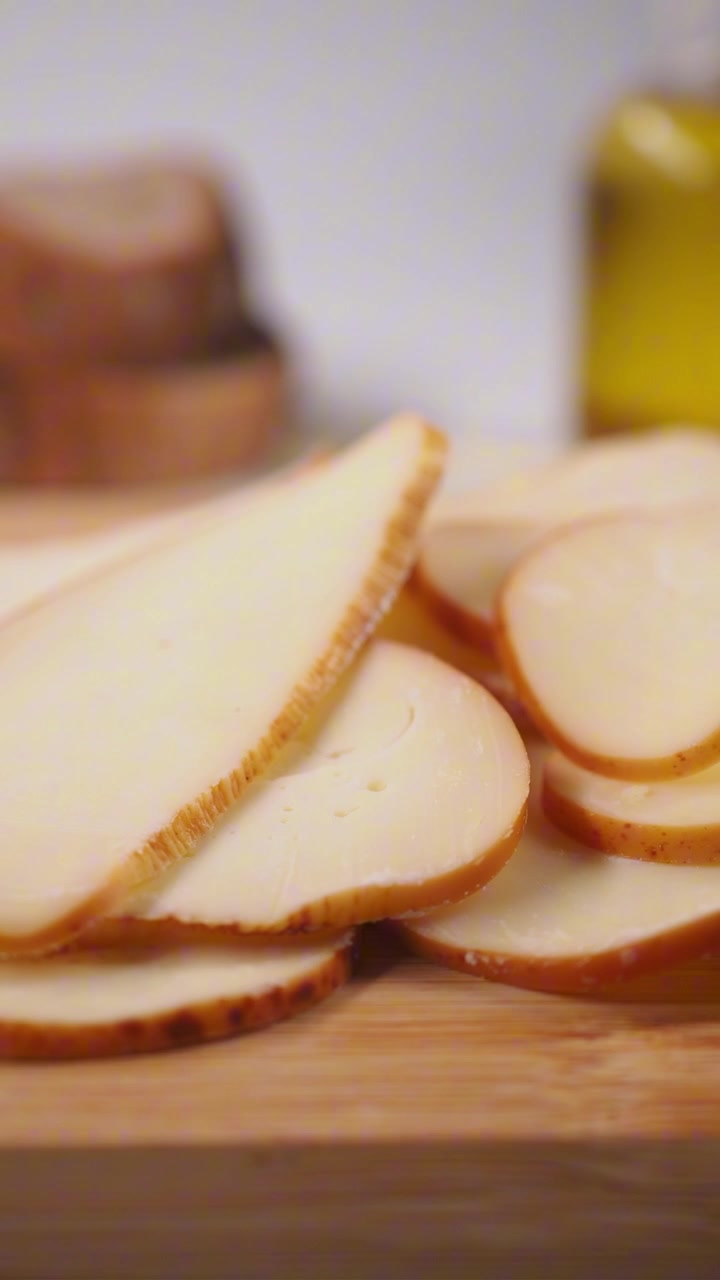 Fette di formaggio fresco con olio d'oliva e pane su un tagliere