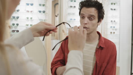 customer trying on glasses at an optical shop