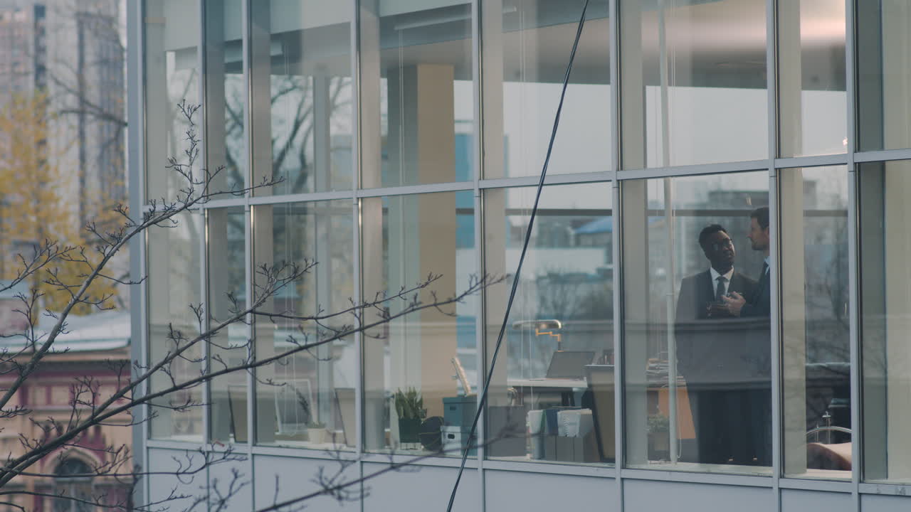 двое мужчин пьют в офисе.