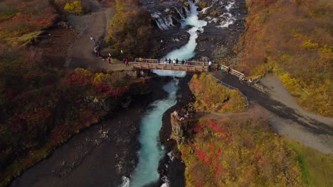 tourists taking pictures from brúarfoss waterfall in iceland