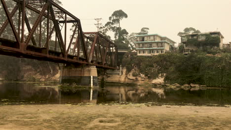 train bridge going over sill water river with house overlooking on the ridge