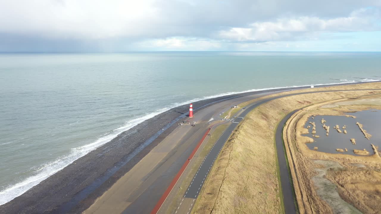 큰 빨간 등대와 함께 앞으로 날아다니는 네덜란드 해안의 드론