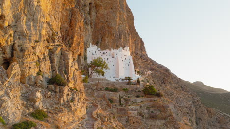 sacred panagia hozoviotissa monastery shining at sunrise against dramatic cliffs of amorgos, greece