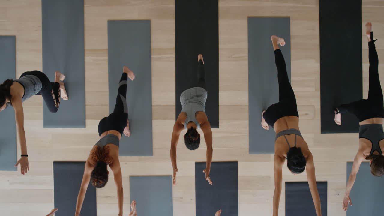 vista dall'alto lezione di yoga donne sane che praticano la posa del guerriero godendo dello stile di vita fitness esercitandosi in studio