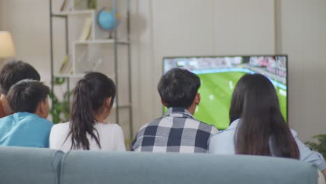 sad asian teenagers friends watching soccer on tv at home