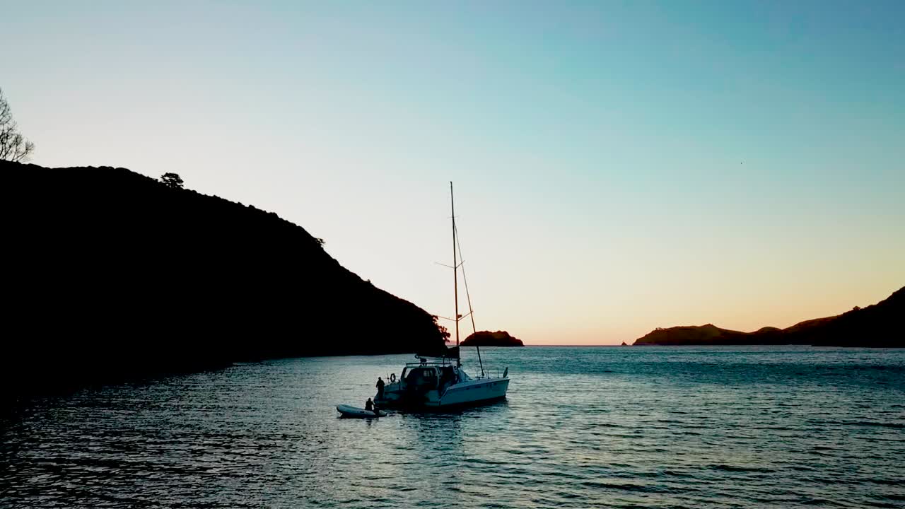 Una lenta inquadratura panoramica dal basso di una barca a vela al tramonto