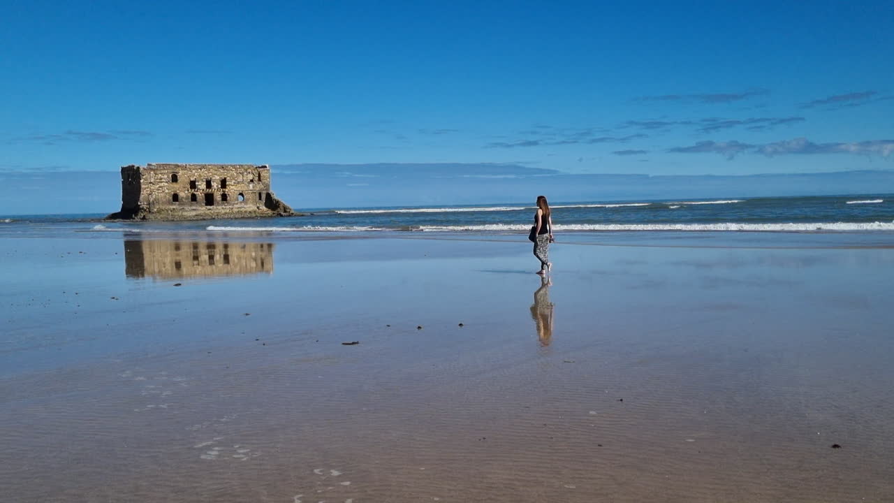Ragazza con i capelli lunghi cammina verso la spiaggia a Casa del Mar, Tarfaya, Marocco