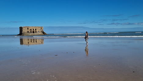 girl with long hair walks towards the beach in casa del mar, tarfaya,, marroco