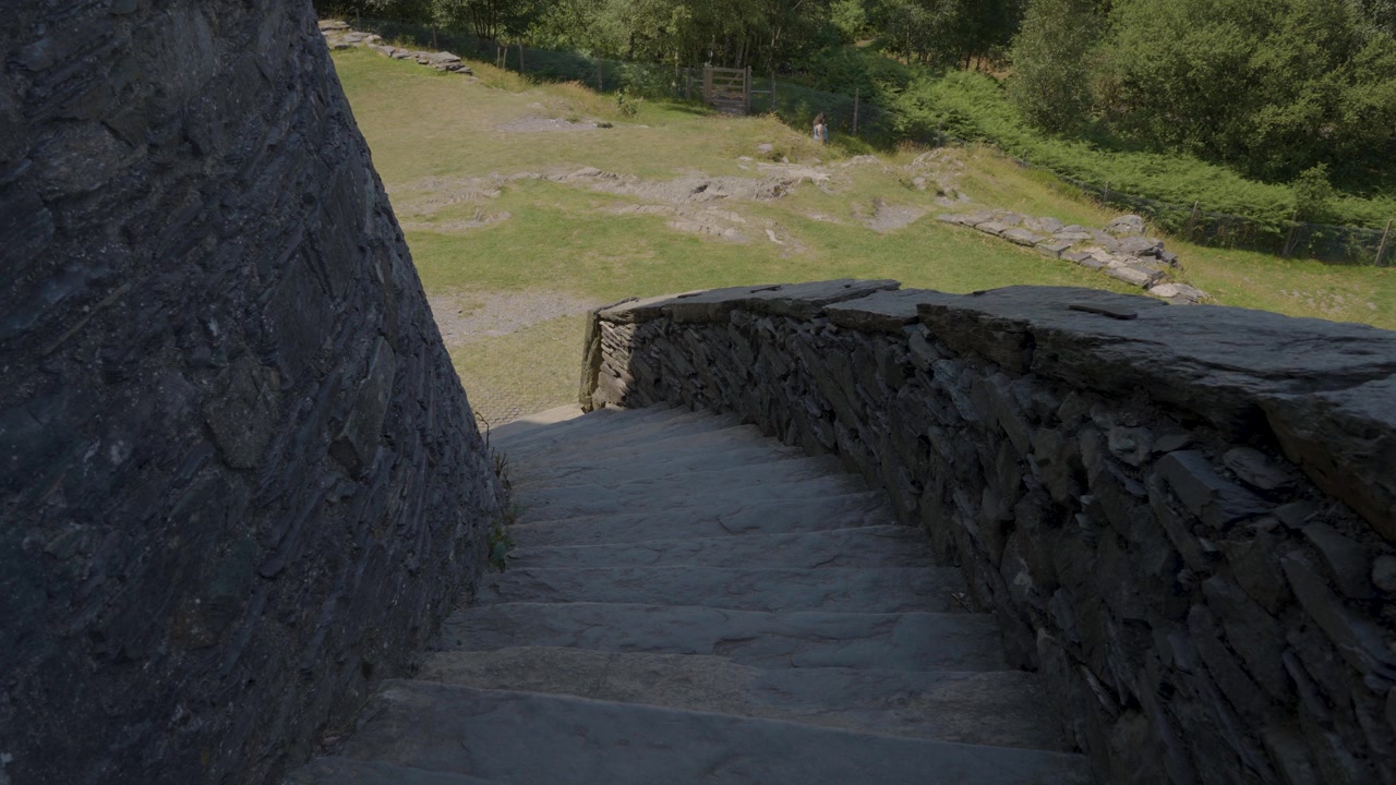 Stabilní záběr zachycující detail zaobleného kamenného schodiště a zdí hradu Dolbadarn. Staré ruiny, které se nacházejí poblíž jezera Lyn Padarn v pohoří Snowdonia. 4K 30fps