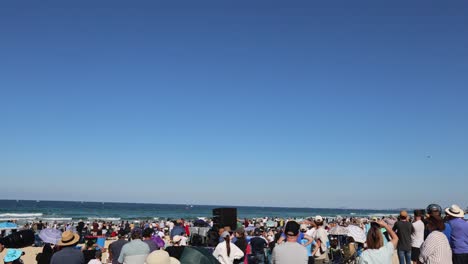 people gathered at beach observing a distant event