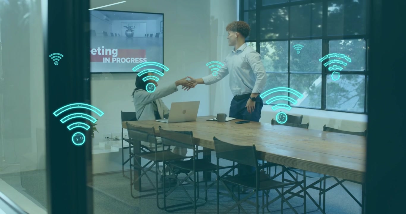 business staff typing in meeting while animated Wi-Fi icons growing over table and shaking hands