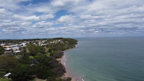 Aerial-view-of-a-beach,-beach-town-and-people-swimming