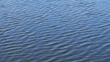 Superficie-De-Agua-Abstracta-Con-Pequeñas-Olas-Y-Reflejo-Del-Cielo