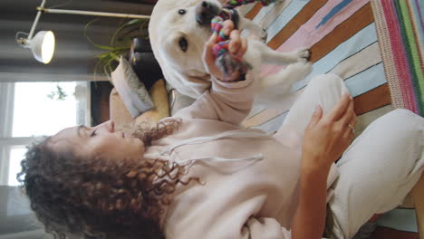 woman playing with her golden retriever at home