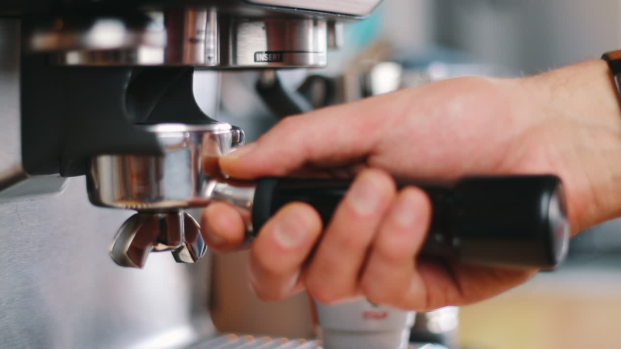 Hand inserting Portafilter into grinder