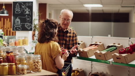vendedor asiste a un cliente anciano de una tienda de alimentos