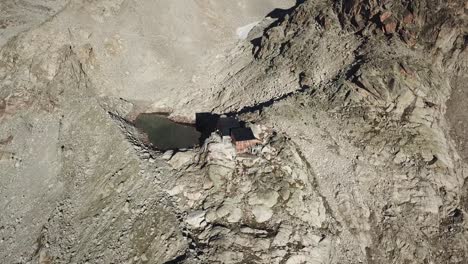 Lago-Alpino-Y-Una-Cabaña-En-Los-Alpes-Suizos,-Montañas-Rocosas,-Salida-Del-Sol