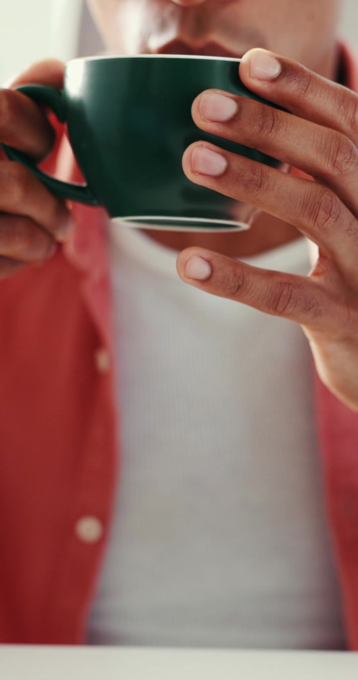 Young Man Drinking Hot Coffee from a Green Mug