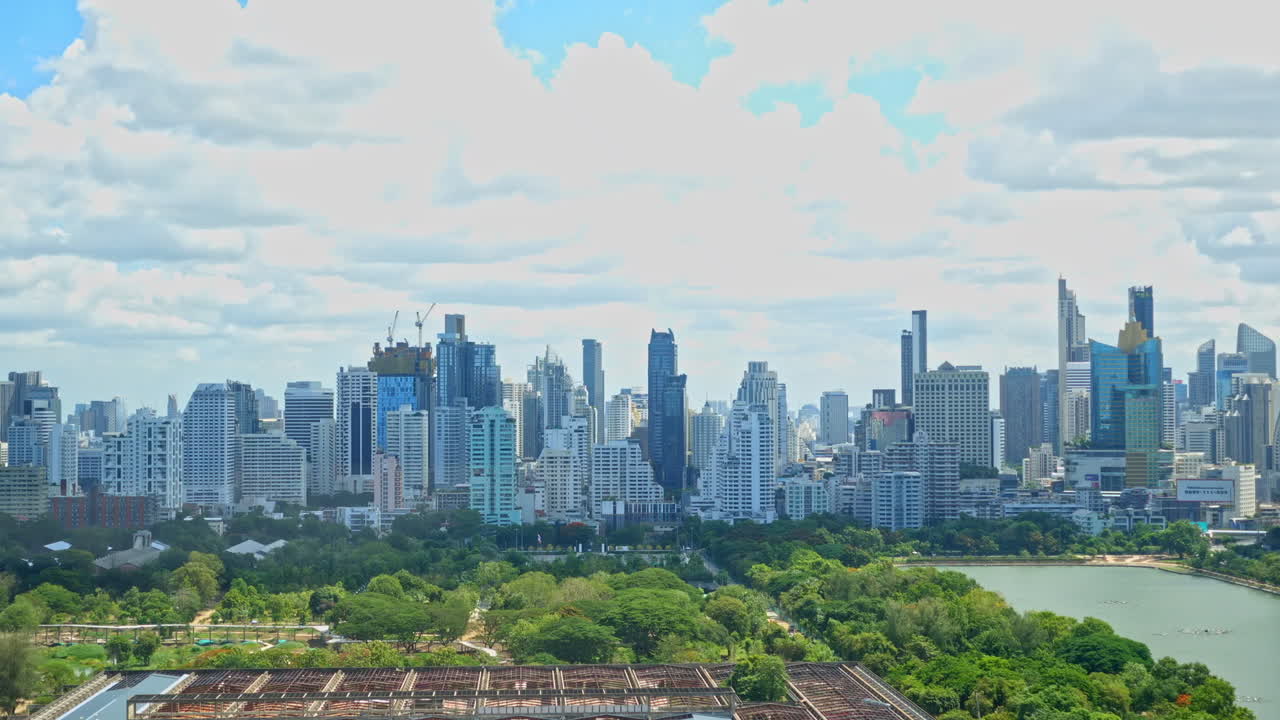 높은 지점에서 낮 시간에 방콕 도시 경관을 가로지르는 구름, 시내 비즈니스 지구의 수많은 고층 빌딩, 벤자키티 공원, cti 타워, 여왕 시리킷 국립 컨벤션 센터 건설