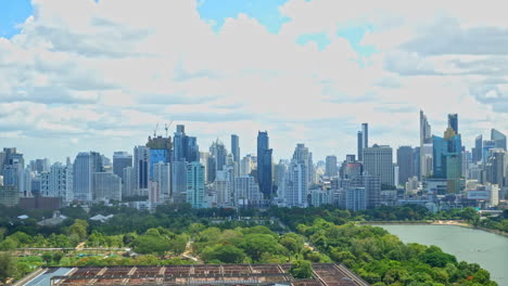 clouds timelapse over bangkok cityscape daytime from a high point, numerous skyscrapers of downtown business district, benjakitti park, cti tower, queen sirikit national convention centre construction