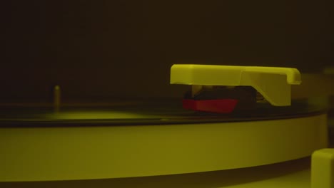 record player needle dropped into groove of a record with slow blinking disco lights