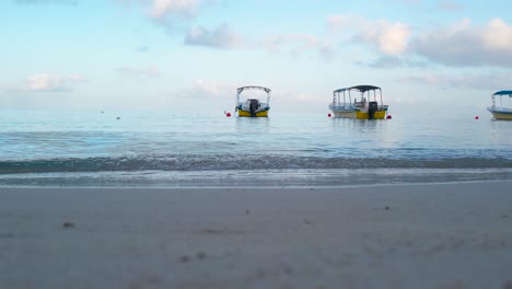 Static-footage-of-White-Boat-on-the-waves-in-turquoise-seawater-on-Caribbean-coast