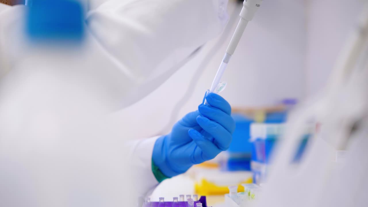 un científico vierte una muestra en un tubo de ensayo