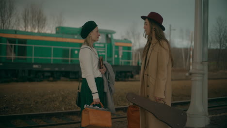 women talking at railway station