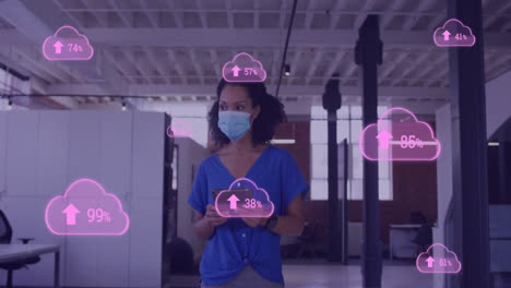 animation of clouds with uploading over biracial female doctor in face mask