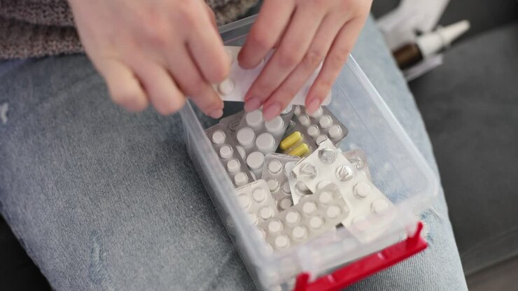 Person organizing and accessing medication from a storage container