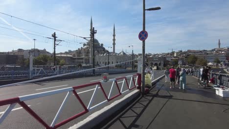 people walk on the galata bridge in istanbul, turkey